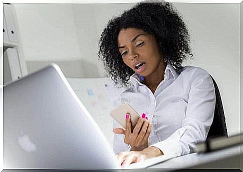 Astonished woman looks at her cell phone