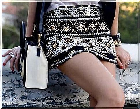 Woman with skirt with pearls shows new trends in accessories