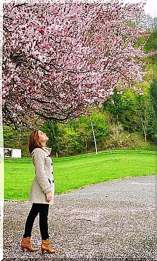 Woman standing under a tree outside