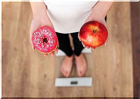 Person holding apple and donut in his hands