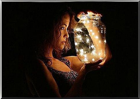 Woman holding jar of fireflies