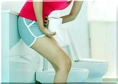 Woman with stomach ache in bathroom