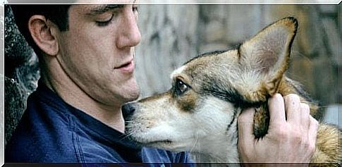 Man sitting and cuddling his dog