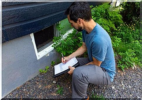 Man bends down and takes notes