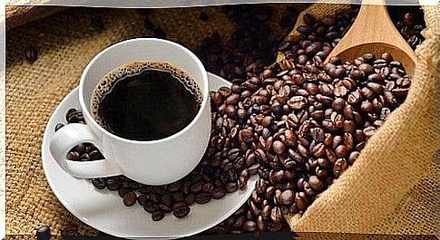 Coffee cup surrounded by coffee beans 