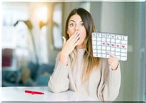 Surprised woman with calendar of menstrual cycle