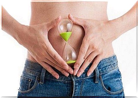 Woman holding hourglass in front of belly