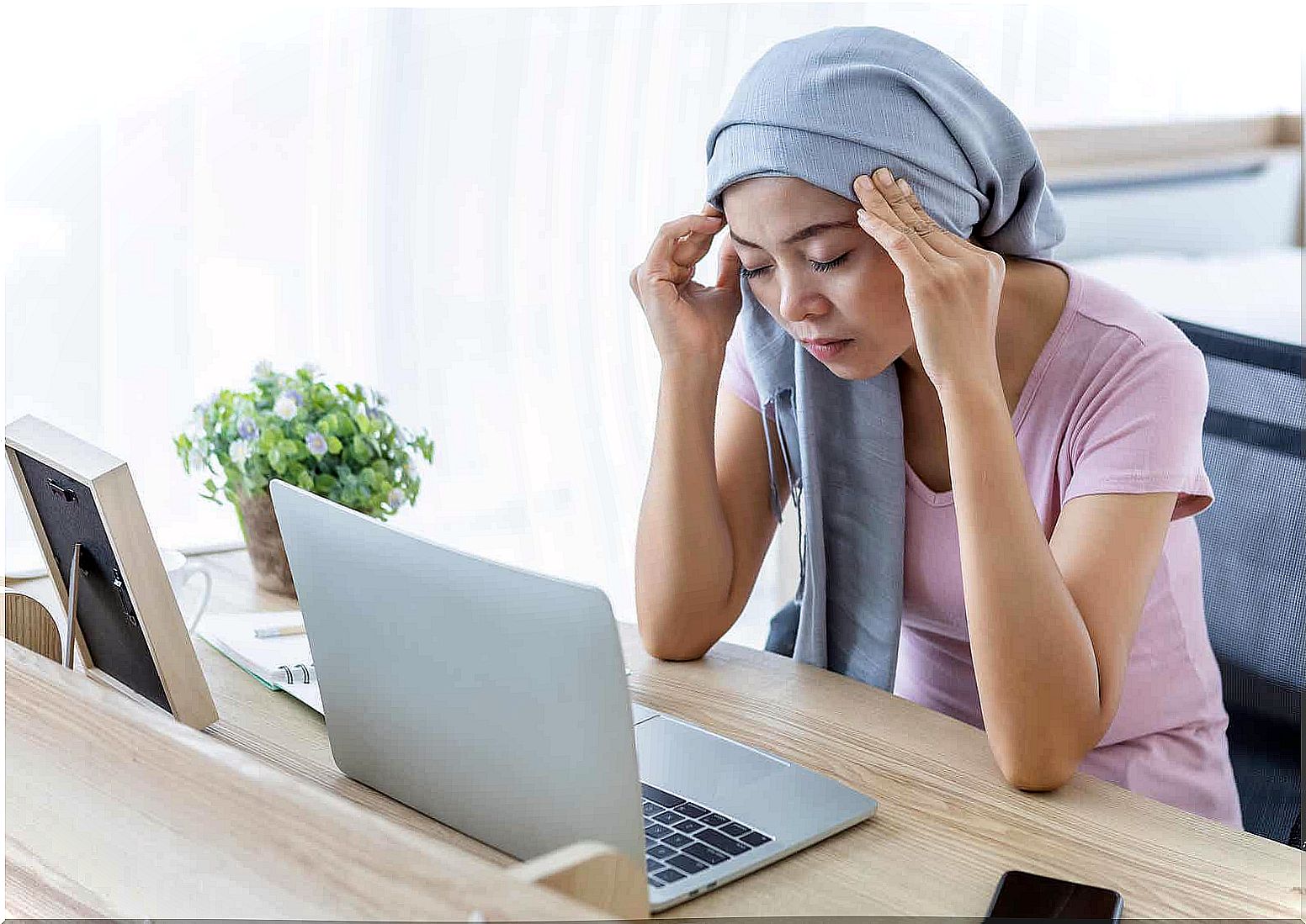 Woman at computer wearing scarf around head 