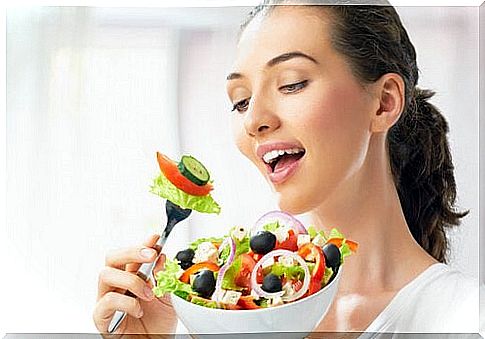 Woman eats salad and follows the new diet pyramid