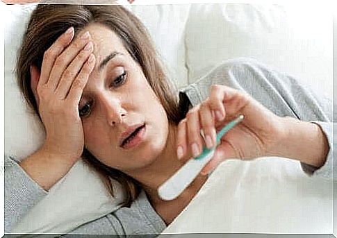 Woman with fever measures her temperature