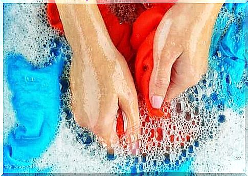 A woman washes clothes with her hands